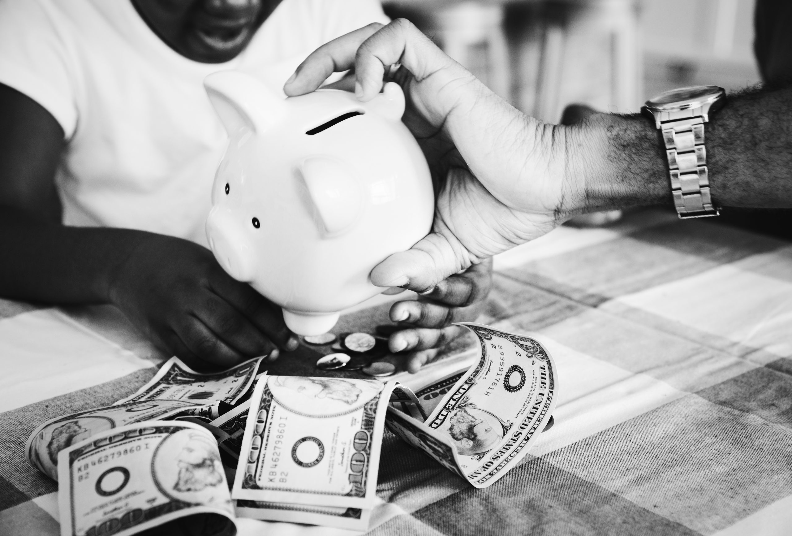 dad and daughter saving money to piggy bank